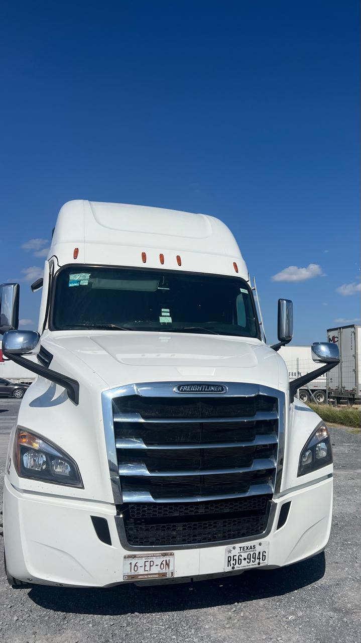 White Freightliner sleeper truck parked under a clear blue sky